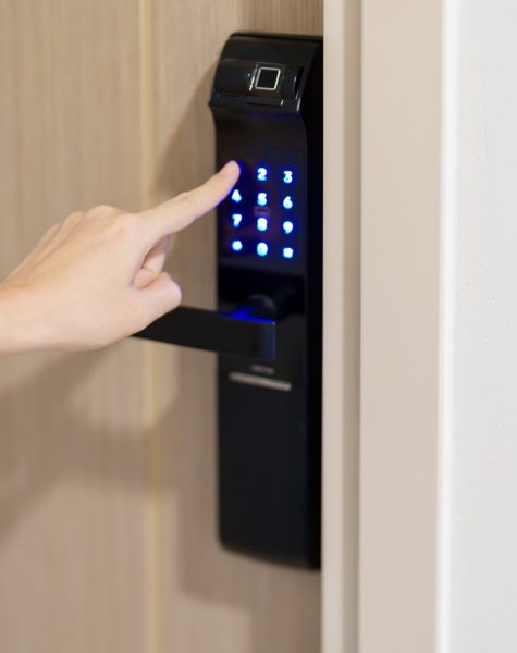 Hand press PIN number for smart digital door lock while open or close the door at home or apartment. NFC Technology, Fingerprint scan, keycard, smartphone and contactless lifestyle concepts