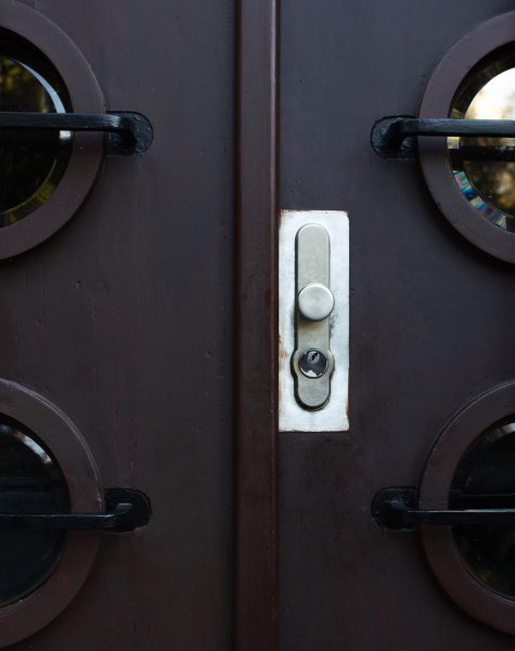 Modern door with a metal handle and little window. Closeup shot